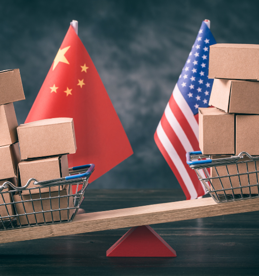 Shopping baskets with boxes, one with a Chinese flag and one with a US flag to depict China/US trade | Generate