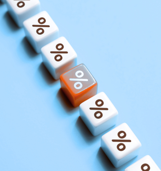 A row of white die with percentage symbols on them, with an orange dice in the middle of the row to represent OCR interest rate cuts | Generate