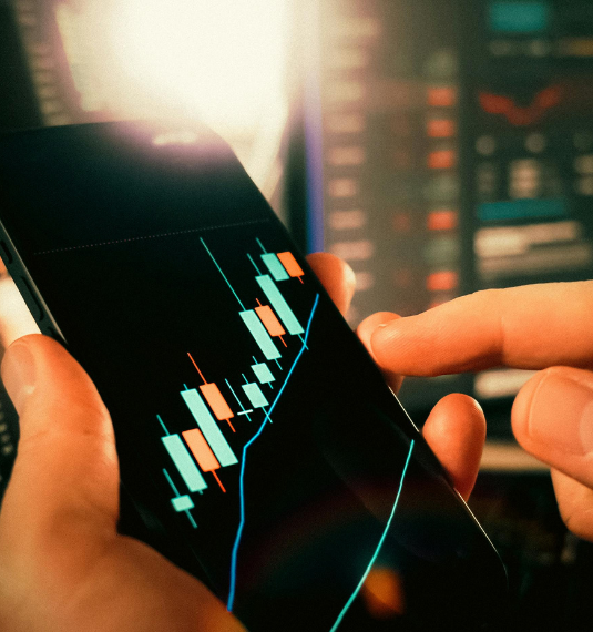 A hand tracking an upward-trending share portfolio on a mobile phone to represent the 2026 market outlook | Generate