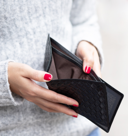 Photo of a woman with red nail polish opening an empty wallet to represent the gap in retirement savings, NZ super, KiwiSaver and retirment cost of living
