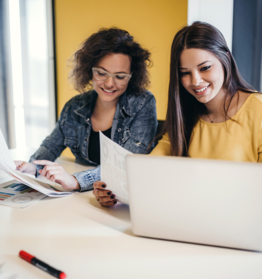 A female financial adviser showing some information to her female client to represent KiwiSaver advice, fund choice, retirement outcomes and the importance of advice