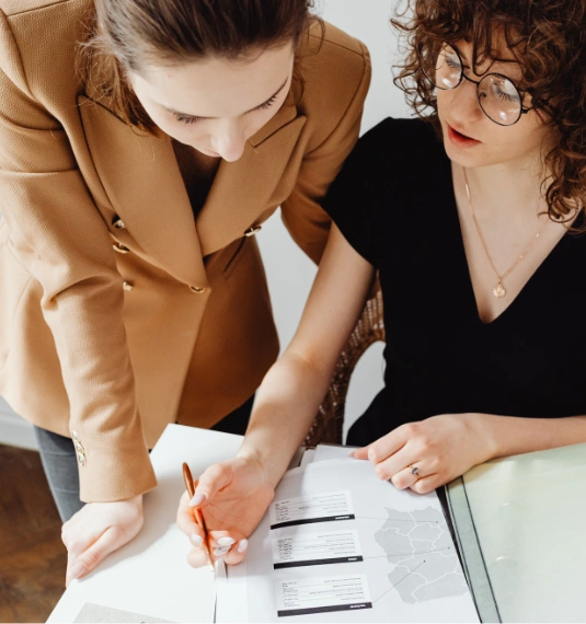 Photo of two women looking over financial documents to represent the fact that most survey respondents have never received expert KiwiSaver advice