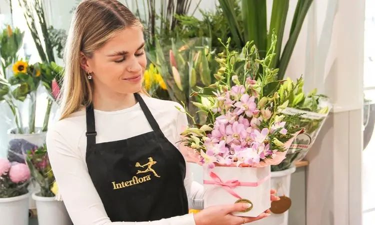 florist holding flower arrangement